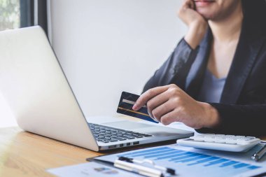 İş kadını tüketici Holding kredi kartı ve laptop yazarak
