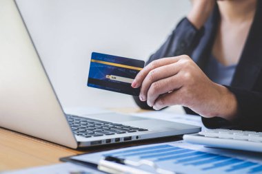 İş kadını tüketici Holding kredi kartı ve laptop yazarak