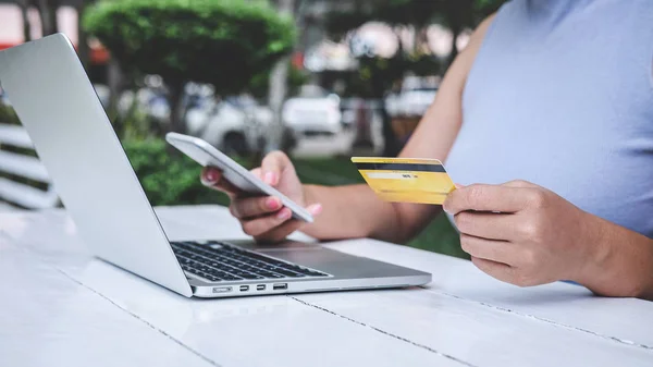 Giovane donna consumatore in possesso di smartphone, carta di credito e digitazione — Foto Stock