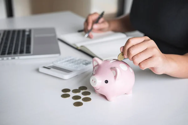 Woman putting golden coin in pink piggy bank for step up growing — Stock Photo, Image