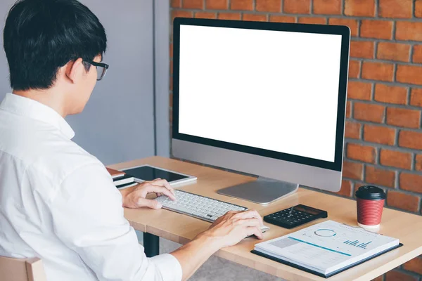 Image of Young man working in front of the computer laptop looki