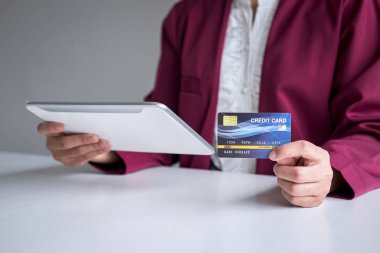 Dijital tablet, kredi kartı ve typ tutan genç kadın tüketici