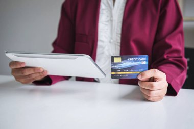 Dijital tablet, kredi kartı ve typ tutan genç kadın tüketici