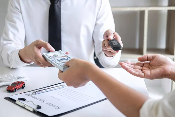 Immobilienmakler-Manager hält Schlüssel für neues Auto und übergibt Frau — Stockfoto