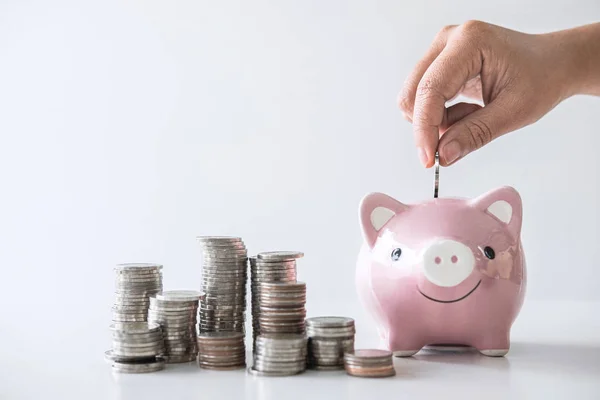 Images of stacking coins pile and Hand putting coin into pink pi — Stock Photo, Image