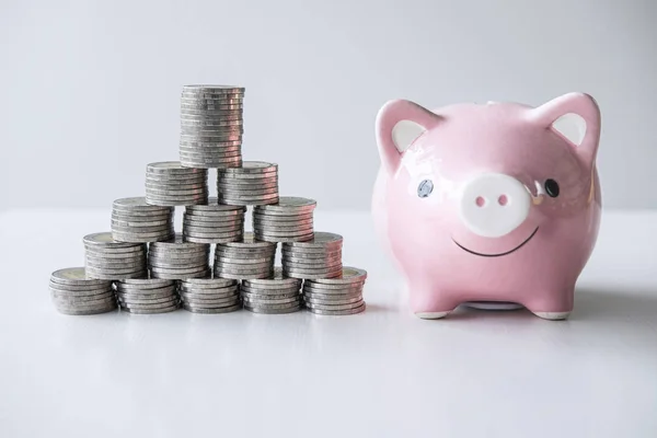 Images of stacking coins pile and pink smiling piggy bank to gro — Stock Photo, Image