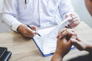Beyaz üniformalı önlük lü profesyonel doktor ve hasta discu