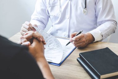 Beyaz üniformalı önlük lü profesyonel doktor ve hasta discu
