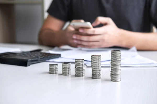 Images of stacking coin pile and Husband using smartphone to cal — Stock Photo, Image