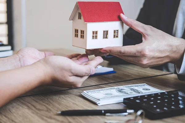 Агент по недвижимости дает дом и ключи клиенту после подписания договора — стоковое фото