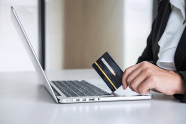 İş kadını tüketici Holding kredi kartı ve laptop yazarak