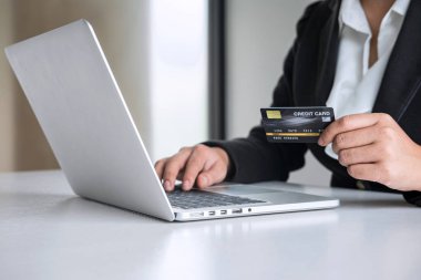 İş kadını tüketici Holding kredi kartı ve laptop yazarak