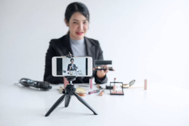İş online sosyal medya, Güzel kadın blogger mevcut öğretici güzellik kozmetik ürün gösteriyor ve online öğretim kayıt sırasında sosyal ağ canlı akış video yayını.