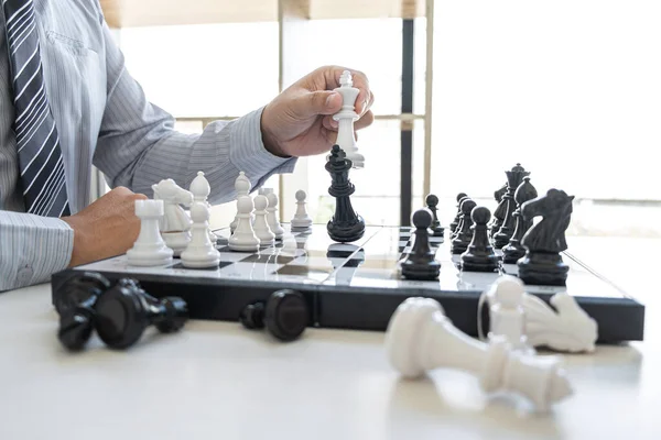 Businessman playing chess and thinking strategy about crash overthrow the opposite team and development analysis for win and successful.