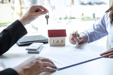 Konut kredisi teklifi ve konut sigortası için onaylı mortgage başvurusu formu ile sözleşme imzaladıktan sonra emlak acentesinin ev anahtarlarını müşteriye vermesi.