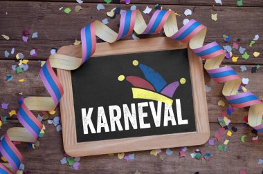 Kara tahta Carnival - Karneval flama ve konfeti ile ahşap arka plan üzerinde Almanca kelime ile
