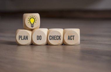 Ampul bir PDCA kavramı ile küpler zar-plan ahşap arka planda hareket kontrol yapmak