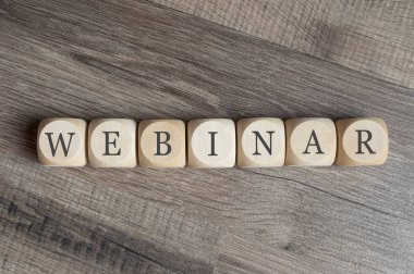 Ahşap arka plan üzerinde tablet ve kalem ile bir işyerinde harfler web semineri ile küpler ve zarlar