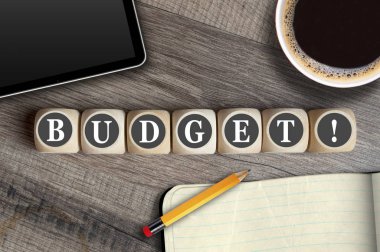 Tablet, eskiz defteri ve bir fincan kahve ile bir işyerinde kelime Bütçe ile küpler ve zar