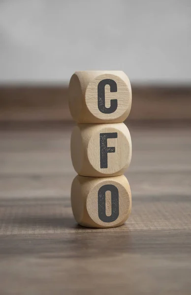 Cubes and  dice with CFO Chief Financial Officer on wooden background
