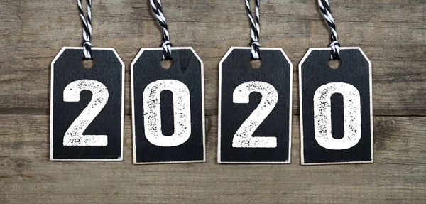 Black hang tags with 2020 on wooden background