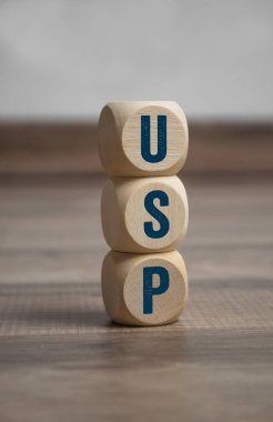 Cubes and dice with acronym USP unique selling proposition or unique selling point on wooden background