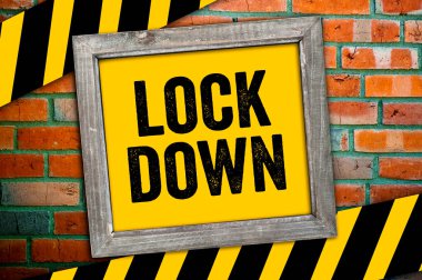 Sarı işaret ve mesaj bir tıkırtı duvarının önünde kilitli.