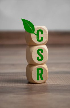 Ahşap arka planda CSR Kurumsal Sorumluluk kısaltması olan küp veya zar