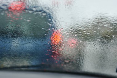 Yağmur cam üzerine bırakır. Araba camından yol görünümü