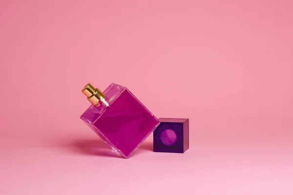 El çantası ve parfüm pembe bir arka plan üzerinde