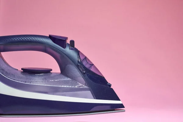 Pembe bir arka plan üzerinde modern elektrikli demir