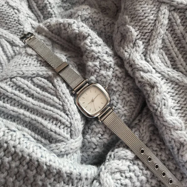 Wrist watch in the background of a sweater
