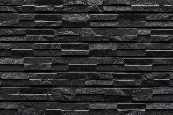 Modern black stone tile wall pattern and background