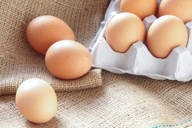 Kahverengi kumaş üzerine kahverengi taze yumurta yığını