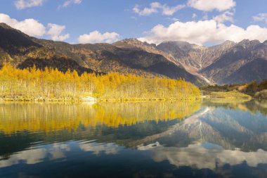 Taisho gölette Kamikochi Nagano Prefecture, Japan.It sonbahar yaprakları ve yansıyan Hodaka Sıradağları ile güzeldir. 