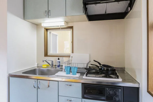 Pan placed on the stove in a small kitchen cabinet