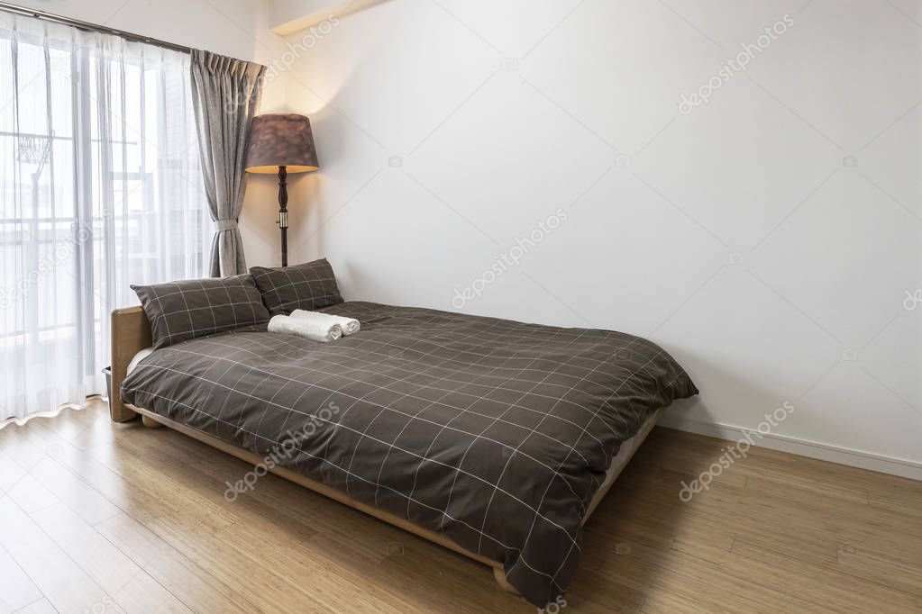 Queen size bed in a small white bedroom