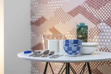 Bardak ve tabaklar, kaşıklar, yemek odasında masaya yerleştirilir