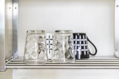 Küçük bir mutfak dolabında paslanmaz çelik zeminüzerine yerleştirilen temiz cam