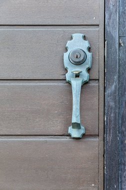 Antika metal kapı kolu ve kahverengi ahşap kapı.