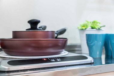 Tencere ve tavalar elektrikli ocağın üstüne konmuş.