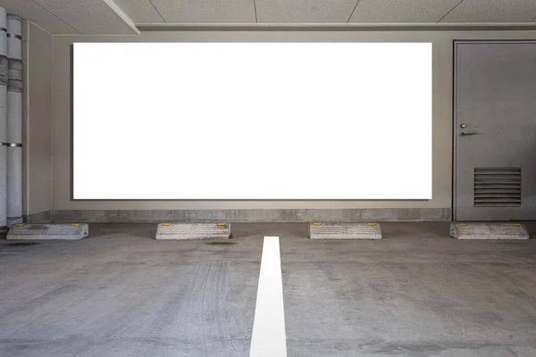 Large blank billboard on the wall of the basement car park