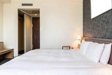 Çift kişilik yatak ve battaniye küçük bir yatak odasında.