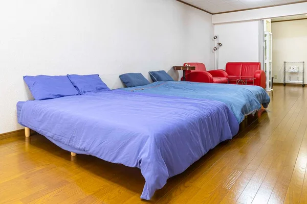 アパートの寝室には大きなダブルベッドと青いベッドが広がっています — ストック写真