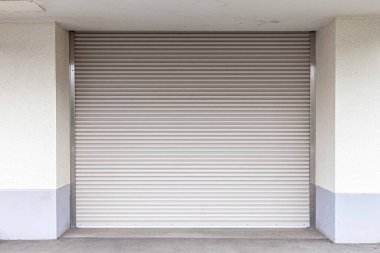 Endüstriyel bir depoda beyaz bir kepenk kapanıyor.