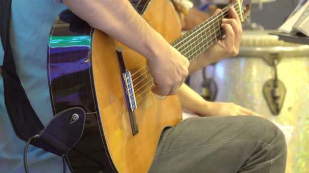 ステージ上でクラシックギターを弾く男の手のクローズアップ — ストック動画