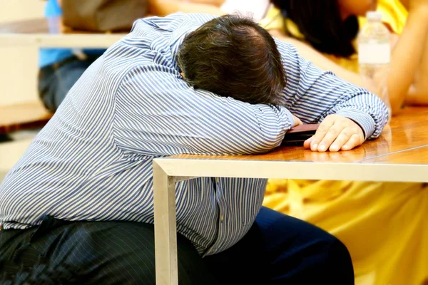 businessman sleeps on desk after Tired overworked