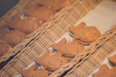 Japon taiyaki, gıda sokak pazarında tatlı kırmızı fasulye ezmesi ile küçük balık şeklinde kek