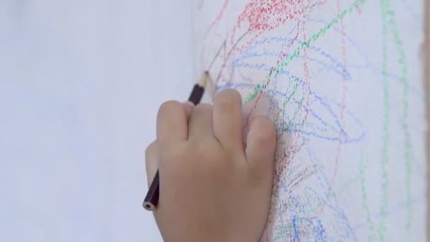 main d'enfant dessin crayon sur le mur 