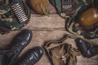 Askeri askeri üniforma, silah, tabanca kılıfı, tabanca, şişesi, çizmeler ahşap arka plan üzerinde. Kopya space.Military arka plan ile düz yatıyordu üstten görünüm